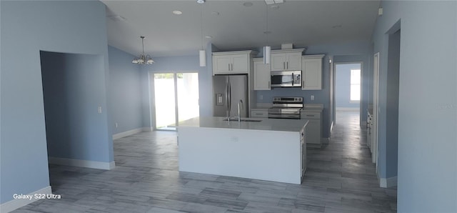 kitchen with lofted ceiling, a healthy amount of sunlight, appliances with stainless steel finishes, and a sink
