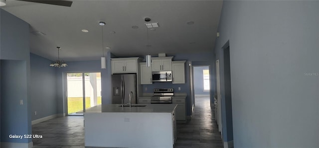 kitchen with baseboards, a sink, appliances with stainless steel finishes, and dark wood finished floors