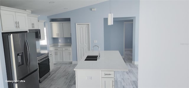 kitchen with lofted ceiling, light countertops, a sink, appliances with stainless steel finishes, and white cabinetry