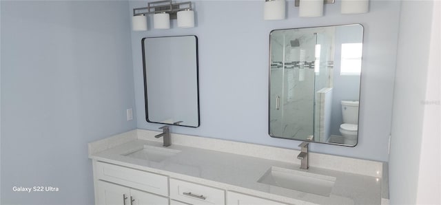 full bathroom with a stall shower, a sink, double vanity, and toilet