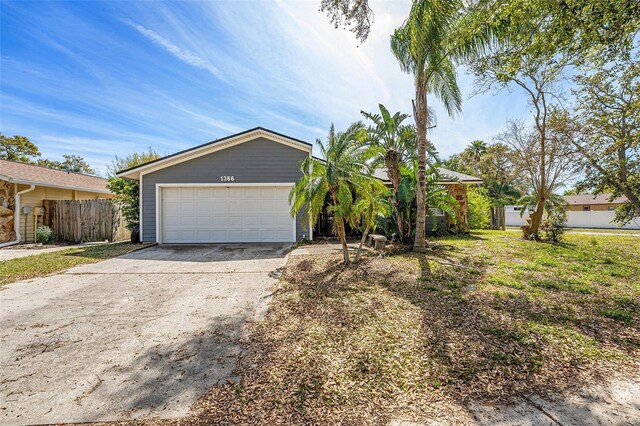 1366 Wexford Dr N, Palm Harbor, FL 34683 - view of front of house with a garage, concrete driveway, and fence