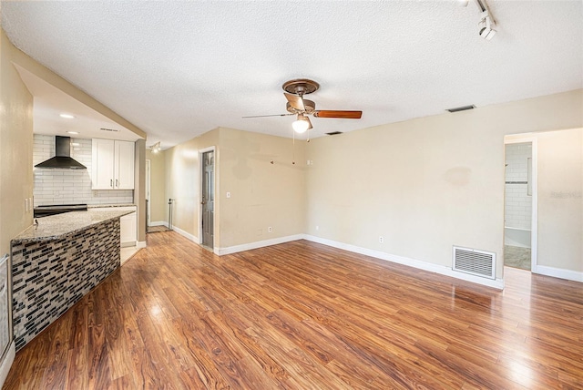 1366 Wexford Dr N, Palm Harbor, FL 34683 - living area featuring visible vents, ceiling fan, a textured ceiling, and light wood-style floors