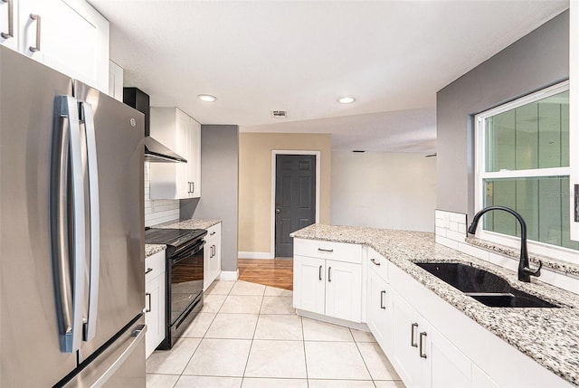 1366 Wexford Dr N, Palm Harbor, FL 34683 - kitchen featuring electric range, freestanding refrigerator, a sink, decorative backsplash, and white cabinets