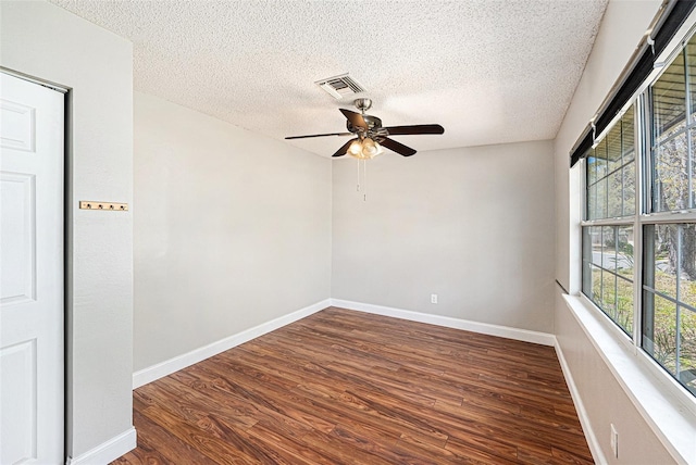 1366 Wexford Dr N, Palm Harbor, FL 34683 - empty room featuring visible vents, a ceiling fan, a textured ceiling, wood finished floors, and baseboards