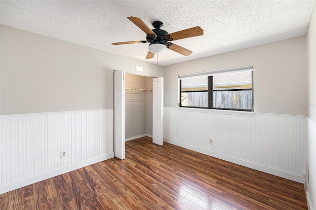 1366 Wexford Dr N, Palm Harbor, FL 34683 - unfurnished bedroom with a closet, a wainscoted wall, and wood finished floors