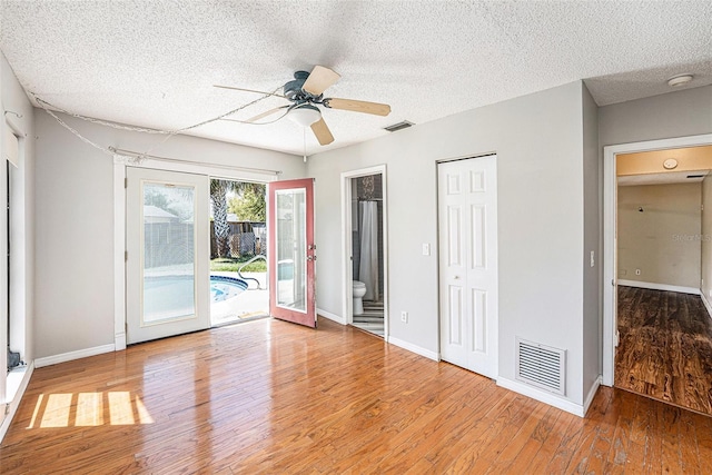 1366 Wexford Dr N, Palm Harbor, FL 34683 - unfurnished bedroom featuring access to exterior, wood finished floors, visible vents, and baseboards