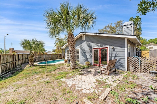 1366 Wexford Dr N, Palm Harbor, FL 34683 - rear view of property with a fenced in pool, french doors, and a fenced backyard