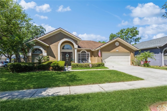 3627 Cypress Meadows Rd, Tampa, FL 33624 - ranch-style home featuring a front lawn, driveway, stucco siding, and an attached garage
