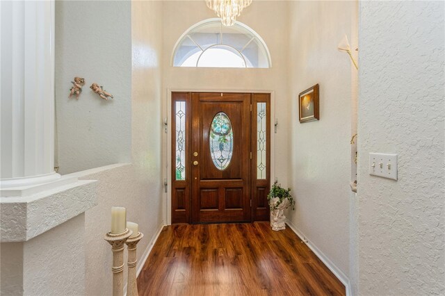 3627 Cypress Meadows Rd, Tampa, FL 33624 - foyer entrance featuring a textured wall, baseboards, a notable chandelier, and wood finished floors