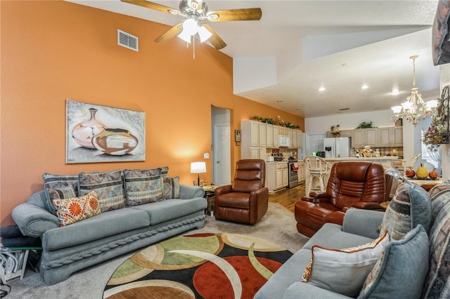 3627 Cypress Meadows Rd, Tampa, FL 33624 - living area featuring ceiling fan with notable chandelier, visible vents, and vaulted ceiling