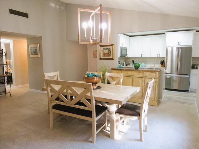 700 Starkey Rd Unit 821, Largo, FL 33771 - dining room with visible vents, baseboards, a chandelier, lofted ceiling, and light carpet