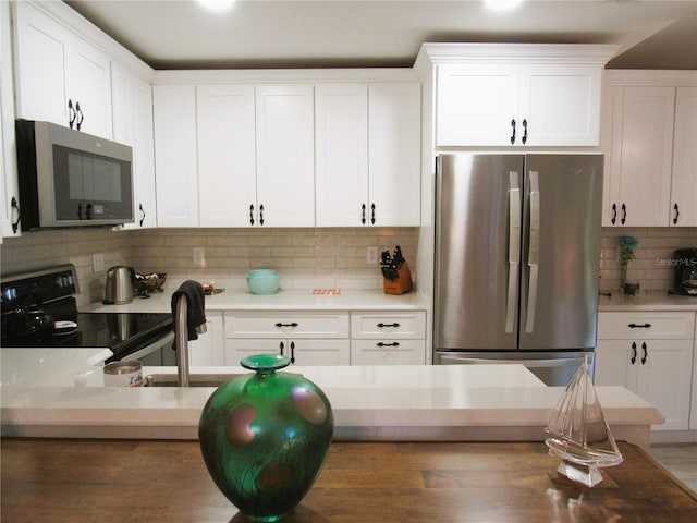 700 Starkey Rd Unit 821, Largo, FL 33771 - kitchen featuring white cabinets, tasteful backsplash, and stainless steel appliances