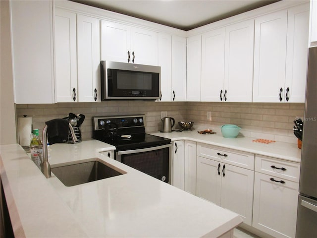 700 Starkey Rd Unit 821, Largo, FL 33771 - kitchen with decorative backsplash, white cabinets, appliances with stainless steel finishes, and a sink