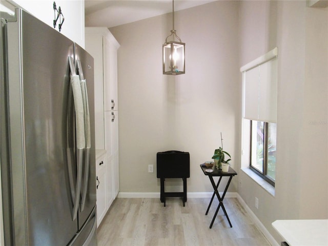 700 Starkey Rd Unit 821, Largo, FL 33771 - kitchen with pendant lighting, freestanding refrigerator, white cabinets, light wood finished floors, and baseboards