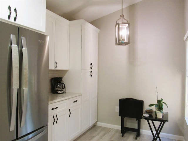 700 Starkey Rd Unit 821, Largo, FL 33771 - kitchen with light countertops, white cabinets, freestanding refrigerator, and pendant lighting