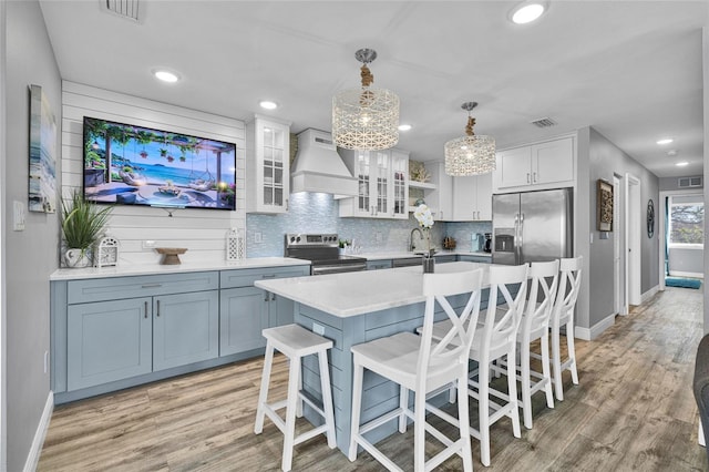 812 Gulf # 3, Indian Rocks Beach, FL 33785 - kitchen with visible vents, stainless steel appliances, premium range hood, and tasteful backsplash
