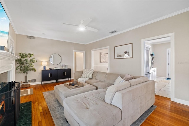 living room with visible vents, a ceiling fan, and hardwood / wood-style flooring