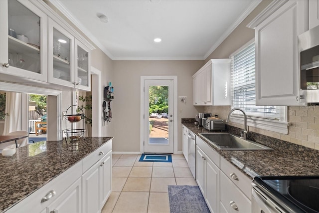 kitchen featuring light tile patterned flooring, ornamental molding, a sink, and stainless steel appliances