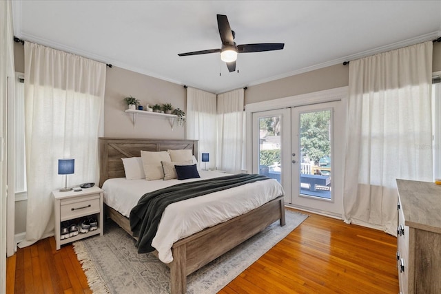 bedroom featuring light wood finished floors, crown molding, french doors, and access to outside