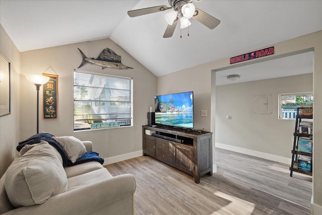 living area featuring baseboards, ceiling fan, vaulted ceiling, and light wood finished floors