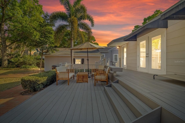 deck at dusk featuring an outdoor living space and french doors