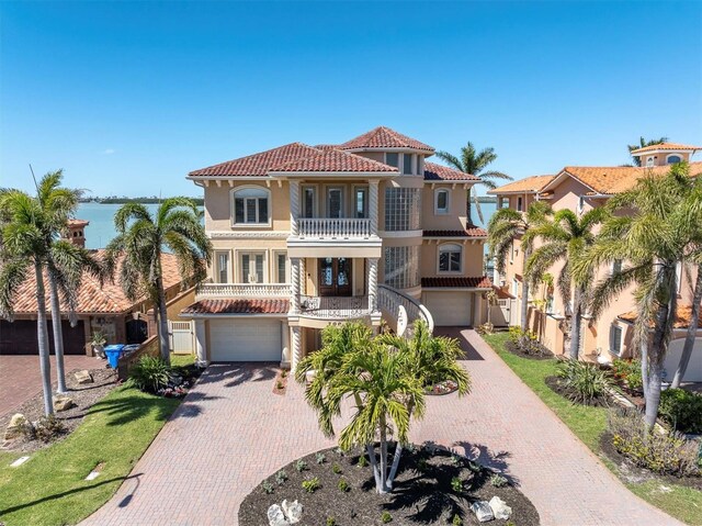 700 126th Ave, Treasure Island, FL 33706 - mediterranean / spanish-style house with a tile roof, a balcony, decorative driveway, and an attached garage