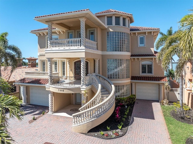 700 126th Ave, Treasure Island, FL 33706 - mediterranean / spanish-style house featuring a tile roof, decorative driveway, stairway, and stucco siding