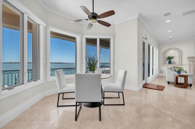 700 126th Ave, Treasure Island, FL 33706 - dining space with a water view, a ceiling fan, crown molding, and baseboards