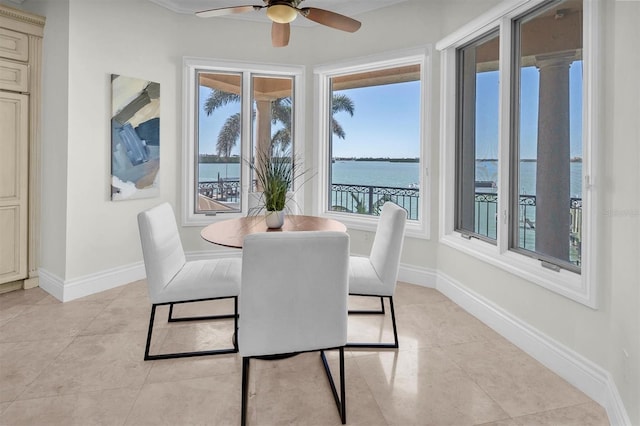700 126th Ave, Treasure Island, FL 33706 - dining space with baseboards, a water view, light tile patterned floors, and a ceiling fan