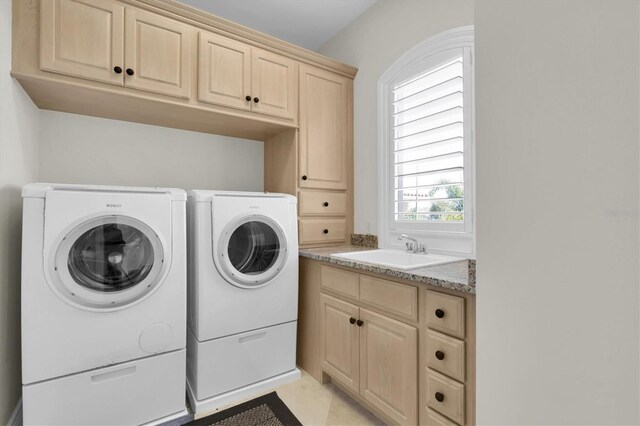 700 126th Ave, Treasure Island, FL 33706 - laundry area with light tile patterned floors, a sink, cabinet space, and washing machine and dryer