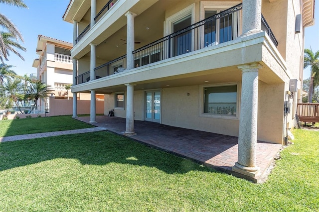 700 126th Ave, Treasure Island, FL 33706 - rear view of house featuring a lawn, stucco siding, and a patio