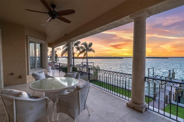 700 126th Ave, Treasure Island, FL 33706 - patio terrace at dusk featuring a balcony, a water view, and ceiling fan
