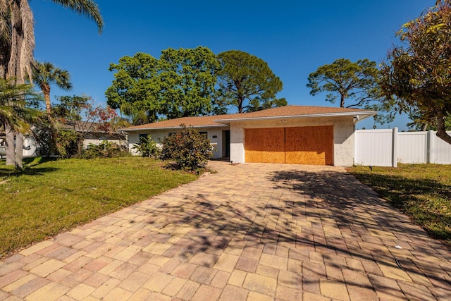 1591 N Dakota Ave NE, Saint Petersburg, FL 33703 - view of front of house featuring fence, decorative driveway, an attached garage, a front yard, and stucco siding
