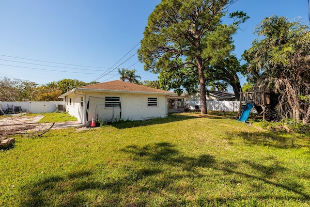 1591 N Dakota Ave NE, Saint Petersburg, FL 33703 - view of yard with a fenced backyard and a playground