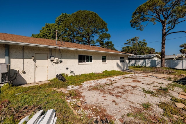 1591 N Dakota Ave NE, Saint Petersburg, FL 33703 - back of property with stucco siding and fence