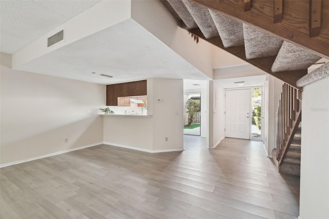 440 Woods Landing Trl, Oldsmar, FL 34677 - foyer featuring stairway, wood finished floors, a textured ceiling, baseboards, and visible vents