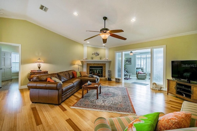 3545 Seaway Dr, New Port Richey, FL 34652 - living area featuring visible vents, ornamental molding, vaulted ceiling, light wood-style flooring, and a ceiling fan