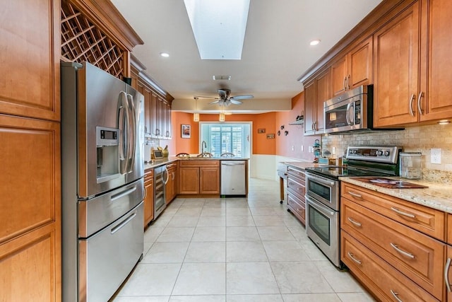 3545 Seaway Dr, New Port Richey, FL 34652 - kitchen featuring beverage cooler, a peninsula, a skylight, stainless steel appliances, and decorative backsplash