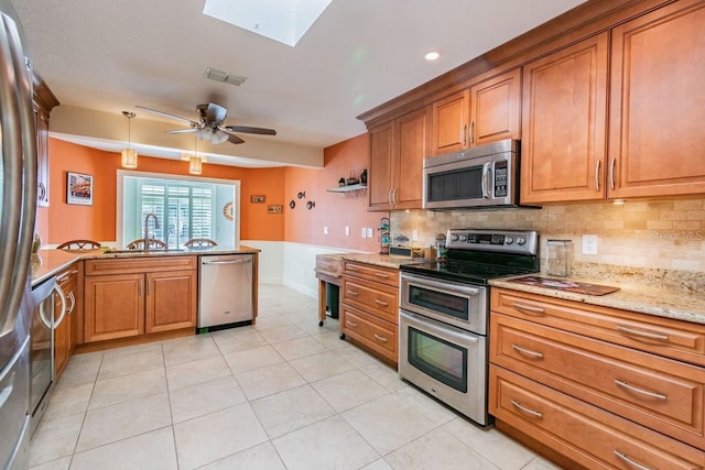 3545 Seaway Dr, New Port Richey, FL 34652 - kitchen with a skylight, visible vents, brown cabinets, and appliances with stainless steel finishes