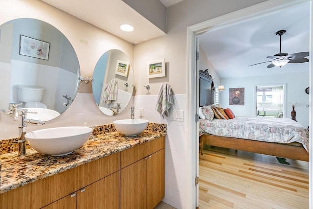 3545 Seaway Dr, New Port Richey, FL 34652 - bathroom featuring a sink, connected bathroom, tile walls, and wood finished floors