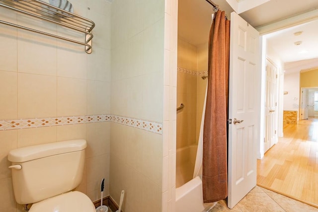 3545 Seaway Dr, New Port Richey, FL 34652 - full bath featuring tile patterned floors, toilet, tile walls, and shower / bath combo with shower curtain