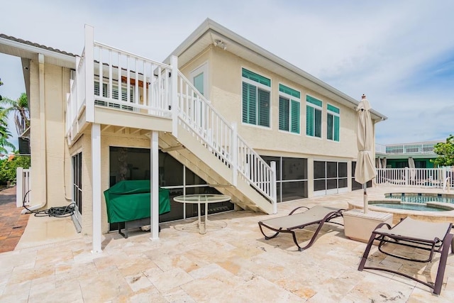3545 Seaway Dr, New Port Richey, FL 34652 - rear view of house featuring a patio area, stucco siding, an in ground hot tub, and stairs