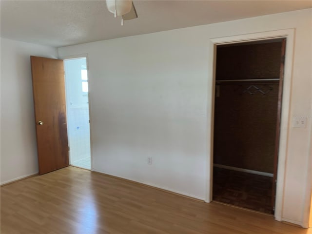 9741 Scenic Dr, Port Richey, FL 34668 - unfurnished bedroom with a spacious closet, light wood-style flooring, a closet, and baseboards