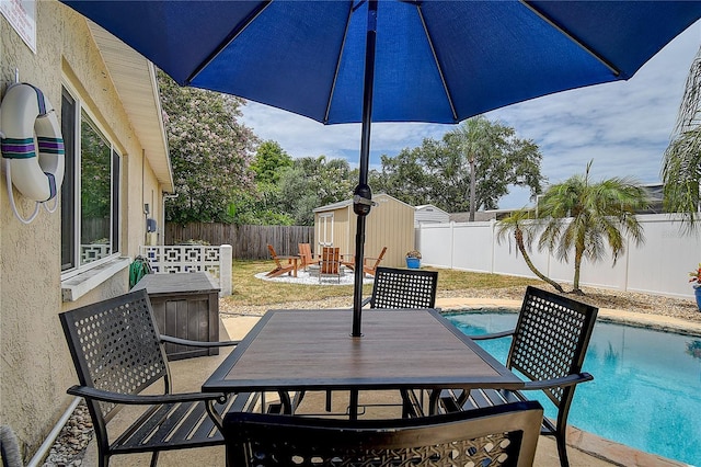 12299 91st Ave N, Seminole, FL 33772 - view of patio featuring a storage unit, an outbuilding, outdoor dining space, a fenced backyard, and a fenced in pool