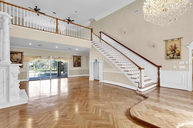 4404 Lake In The Woods Dr, Spring Hill, FL 34607 - unfurnished living room with a towering ceiling, a chandelier, stairway, crown molding, and ornate columns