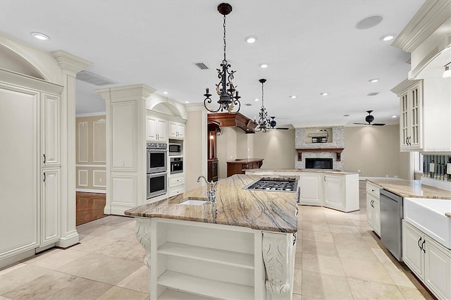 4404 Lake In The Woods Dr, Spring Hill, FL 34607 - kitchen featuring open shelves, an island with sink, a ceiling fan, appliances with stainless steel finishes, and light stone counters