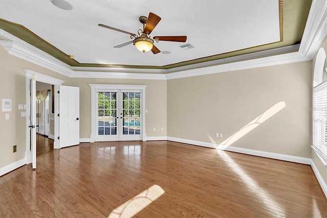 4404 Lake In The Woods Dr, Spring Hill, FL 34607 - spare room featuring french doors, a tray ceiling, ornamental molding, wood finished floors, and a ceiling fan