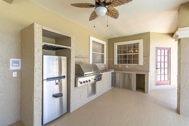 4404 Lake In The Woods Dr, Spring Hill, FL 34607 - kitchen featuring a ceiling fan, freestanding refrigerator, a sink, and a textured wall
