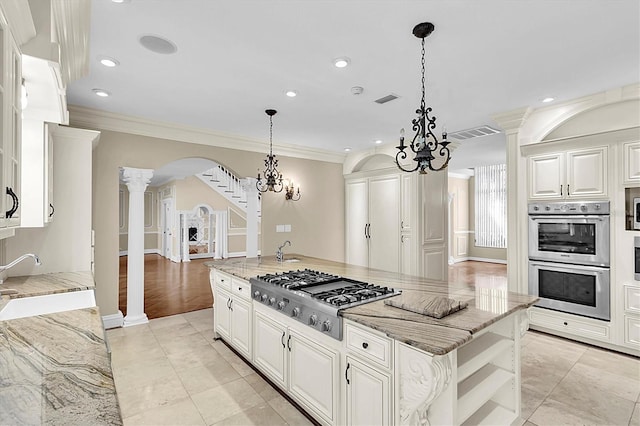 4404 Lake In The Woods Dr, Spring Hill, FL 34607 - kitchen with stainless steel appliances, decorative columns, light stone counters, arched walkways, and a sink