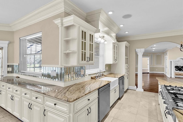 4404 Lake In The Woods Dr, Spring Hill, FL 34607 - kitchen featuring decorative columns, stainless steel appliances, arched walkways, light stone counters, and crown molding